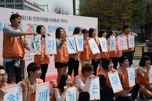 제21회 전국자원봉사 대축제 개막식 중 자원봉사자들이 슬로건을 들고 있습니다